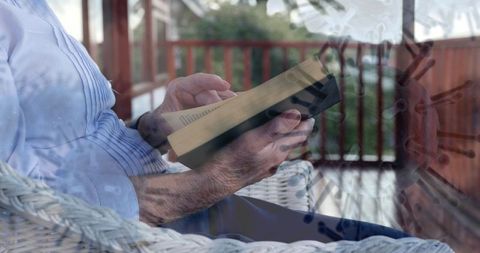 Elderly person reading on porch amid pandemic lockdown