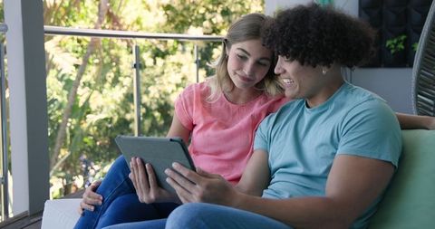 Young Couple Enjoying Tablet Time on Balcony