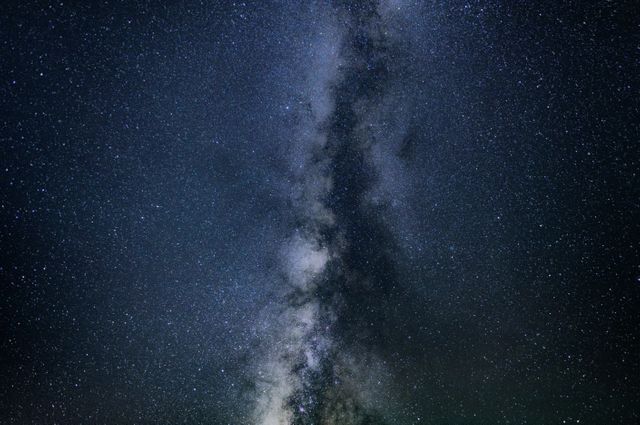 Milky Way galaxy stretching across night sky, filled with countless stars creating a breathtaking celestial view. Ideal for use in educational materials, astronomy presentations, space-themed designs, or nature and science blogs.