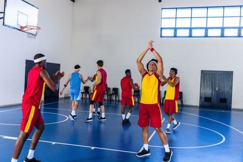 Diverse athletes celebrating victory on indoor basketball court