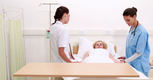 Nurses are checking on a patient in a hospital bed. This image conveys a professional healthcare environment and can be used for websites, articles, or advertisements related to hospitals, medical care, nursing, patient treatment, and teamwork in healthcare.