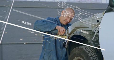 Mechanic grinding fender sparks flying during auto body repair in workshop