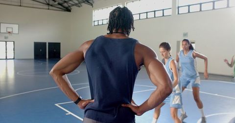 Coach watching players training in indoor gym