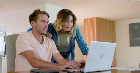Couple Collaborating on Laptop at Home for Work Project