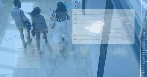 Three colleagues walking through modern office atrium with glass facades and data overlay