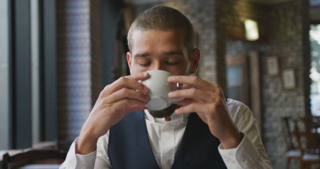 Young Man Drinking Coffee in Cozy Cafe Setting - Download Free Stock Images Pikwizard.com