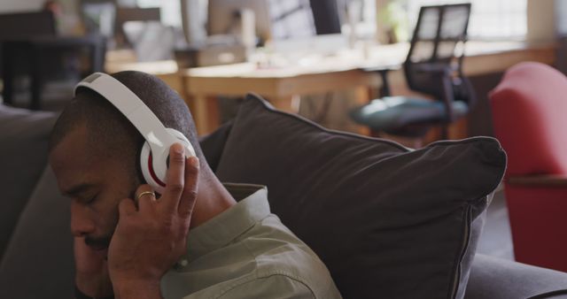 Man Relaxing with Headphones in Modern Office Lounge - Download Free Stock Images Pikwizard.com