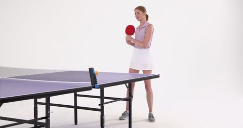 Woman playing table tennis in modern studio space