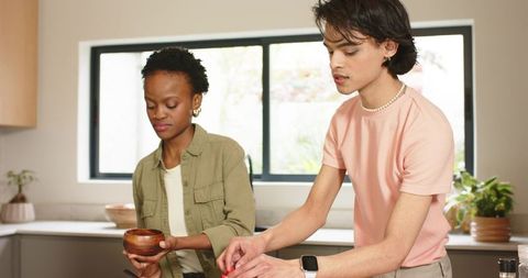 Multicultural couple preparing healthy dinner together in bright modern kitchen