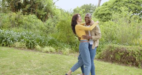 Romantic couple dancing in garden surrounded by lush nature