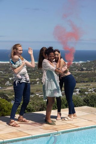 Diverse Friends Celebrating by Pool with Smoke Flare and Baby