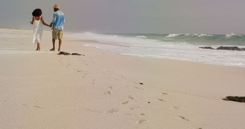Romantic African American Couple Walking Hand in Hand on Serene Beach - Download Free Stock Images Pikwizard.com