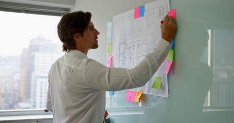 Executive Strategizing on Glass Board with Sticky Notes in Modern Office - Download Free Stock Images Pikwizard.com