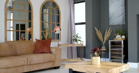Contemporary boho living room with tan leather sofa copper arc lamp timber coffee table