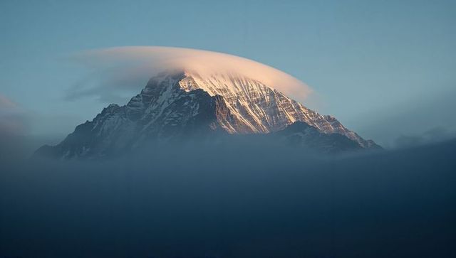 Snow-Capped Peak Catching Light Above Alpine Fog with Lenticular Cloud, Minimalist Sunrise