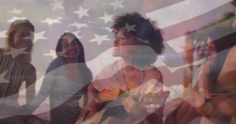 Curly-haired woman playing acoustic guitar with friends overlaid by american flag