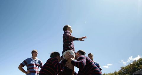 Rugby team lifting jumper in lineout showing teamwork and athletic power outdoors