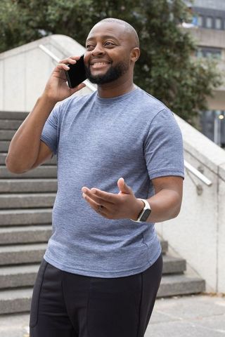 Smiling african american man talking on smartphone outdoors on urban stairs