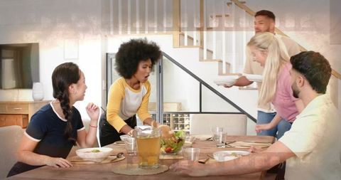 Diverse Friends Serving Salad at Wooden Dining Table During Casual Home Dinner Gathering