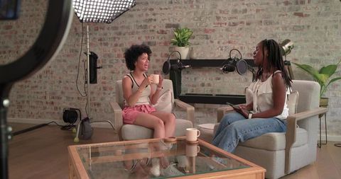 African american women hosting cozy podcast interview in brick wall studio