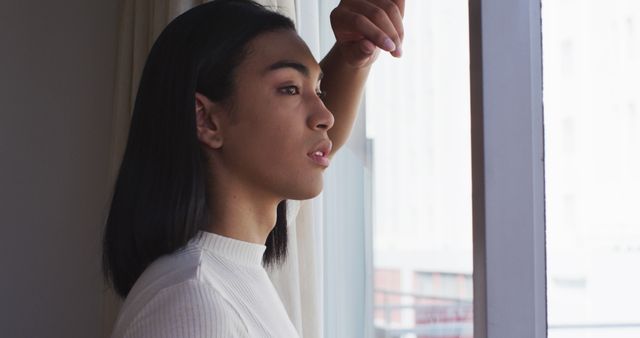 Pensive Young Man Gazing Through Window Thoughtfully - Download Free Stock Images Pikwizard.com