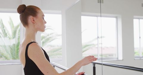 Ballet Dancer Gracing Barre in Sunlit Studio