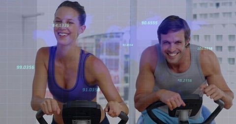 Motivated Duo Exercising on Stationary Bikes with Digital Metrics Overlay