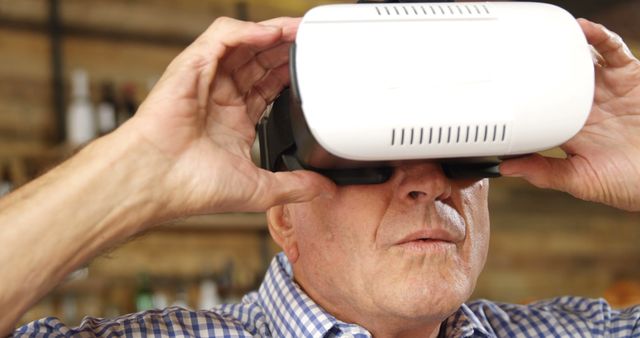 Senior man adjusting VR headset and exploring virtual reality world. Ideal for illustrating technology adapting to all ages, innovation in entertainment, and elderly embracing modern technology.