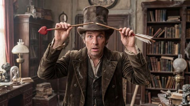 Victorian gentleman wearing top hat holding heart-tipped arrow above head in vintage study