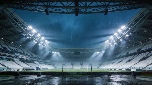 Rain-soaked empty football stadium at night with floodlights and misty reflections on pitch