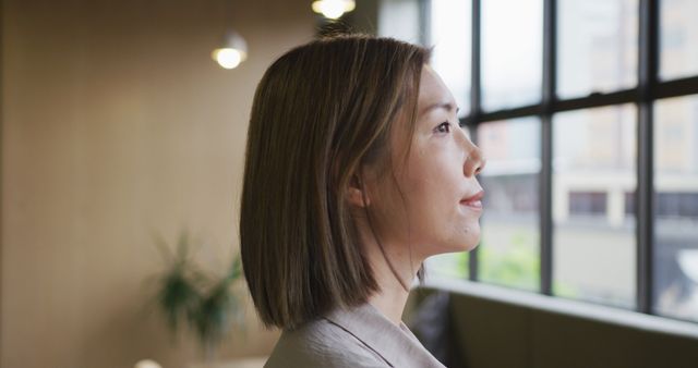 Confident Businesswoman Reflecting by Window in Office - Download Free Stock Images Pikwizard.com