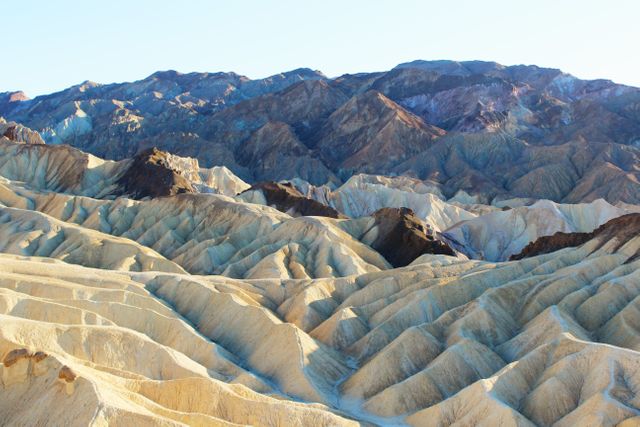 Death Valley’s Zabriskie Point features unique and colorful eroded rock formations forming spectacular patterns. Great for illustrating natural wonders, geological studies, travel content, and promotional materials for national parks or outdoor activities.