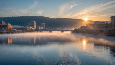 Sunrise over river with majestic bridge and urban silhouette, knoxville concept