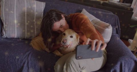 Woman Cuddling Dog While Snapping Selfie on Cozy Couch
