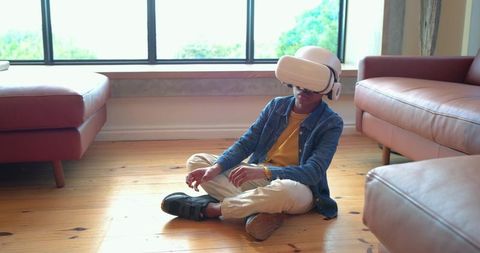 African american child exploring virtual reality headset seated on living room floor