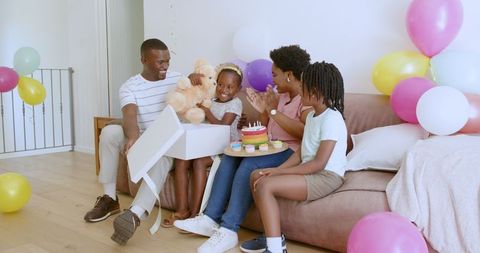 African American Family Celebrating at Home with Cake and Balloons