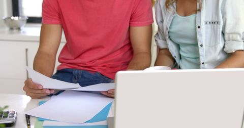 Couple Reviewing Documents Together at Home Office