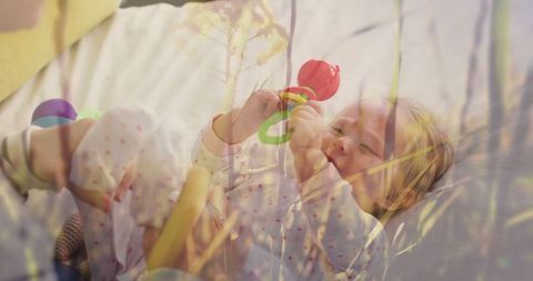 Infant in Pajamas with Rattle and Plant Reflection
