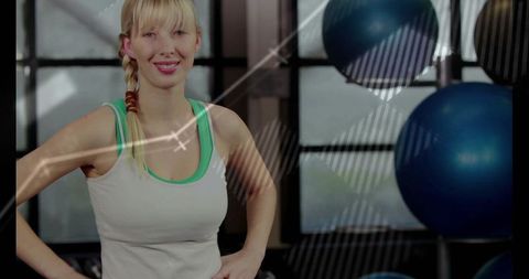 Fitness instructor in modern gym posing with exercise balls
