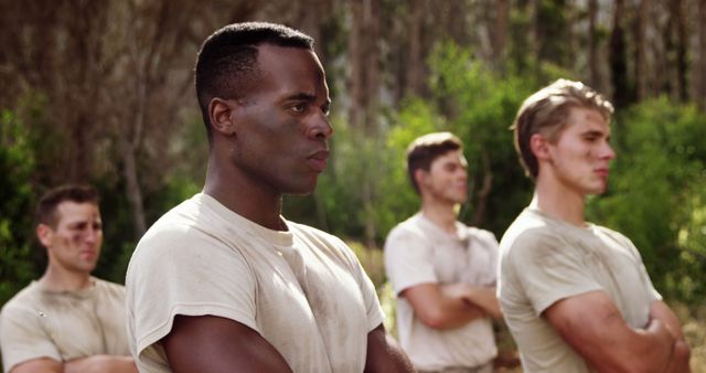 Young African American man and young Caucasian men outdoors, with copy space. They appear focused and determined in a team-building exercise or training session.