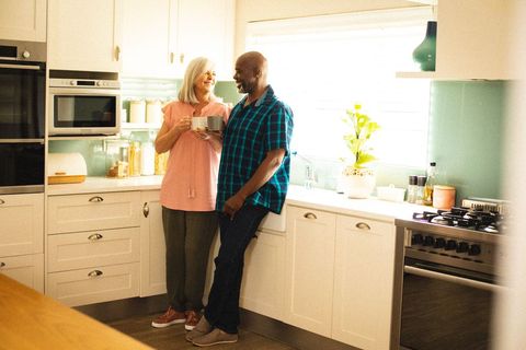 Happy Senior Couple Sharing Coffee in Bright Modern Kitchen
