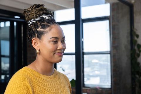 Young Woman in Urban Loft Office Setting with Stylish Accessories