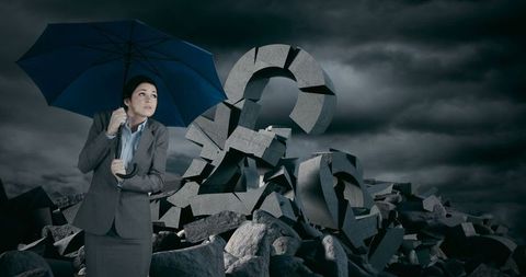 Businesswoman Protecting Against Financial Crisis with Umbrella