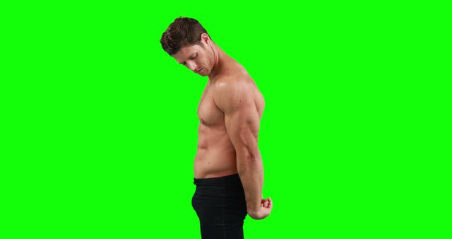 Fit shirtless man flexing muscles against green screen. Ideal for fitness, health, and exercise promotions. Perfect for creating gym advertisements, workout tutorials, and online fitness content. Green screen allows easy customization and background change in post-production.