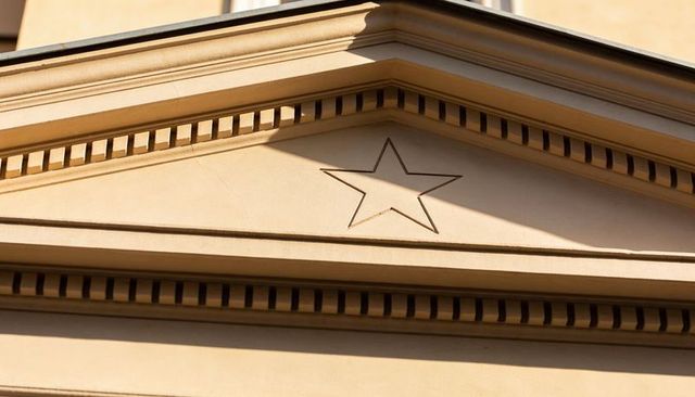Neoclassical pediment featuring recessed five-point star, dentil cornice and shadow detail