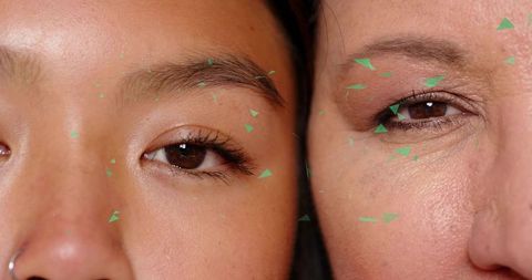 Two women sharing intimate closeup with green confetti, natural skin texture, lashes