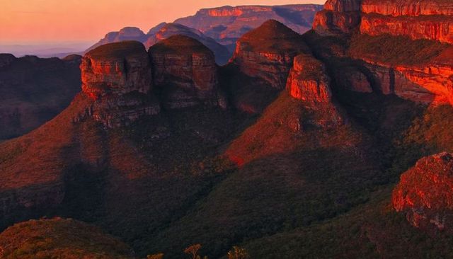 Sunset light glowing sandstone domes and layered cliffs over rugged canyon vista