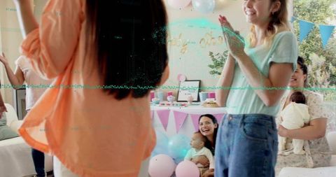 Smiling guests celebrating pastel baby shower in living room with cake, balloons, bunting