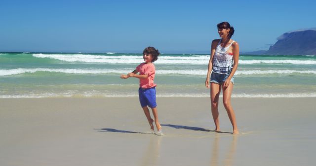 Mother and Child Enjoying Sunny Day at Beautiful Beach - Download Free Stock Images Pikwizard.com