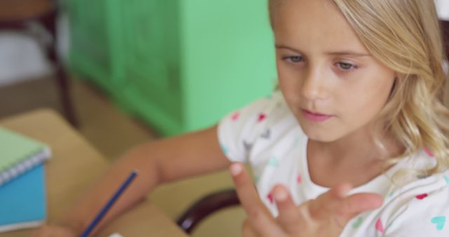 Young girl concentrating on classroom task - Download Free Stock Images Pikwizard.com